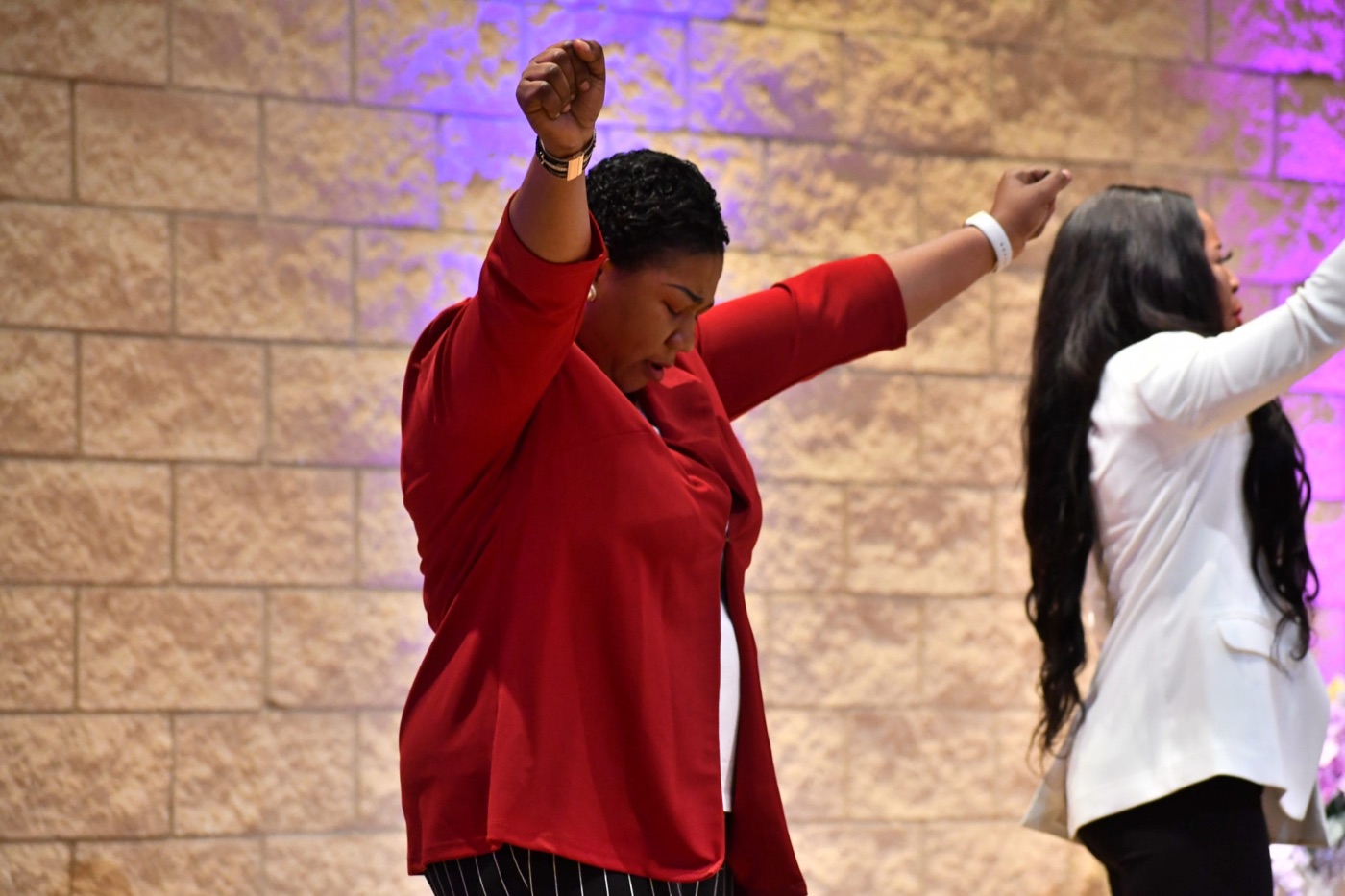A worshipper with hands lifted during a service
